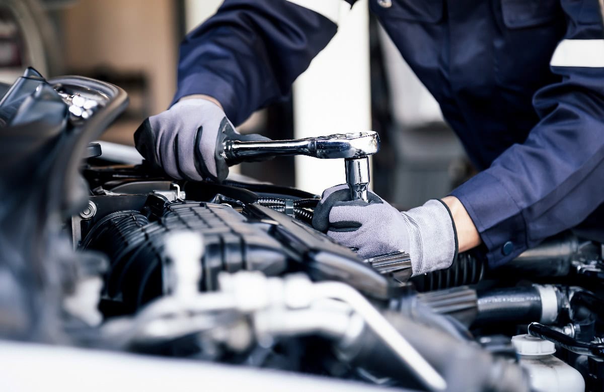 Professioneller Mechaniker bei der Arbeit am Motor eines Autos